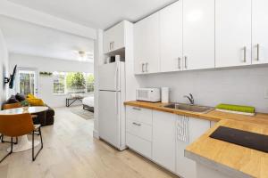 a kitchen with white cabinets and a white refrigerator at Lovely Studio in the Heart of Victoria Park in Fort Lauderdale
