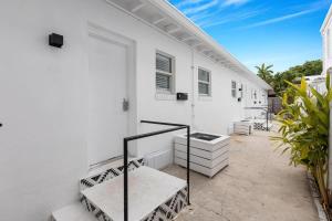 een wit huis met een trap en een patio bij Lovely Studio in the Heart of Victoria Park in Fort Lauderdale