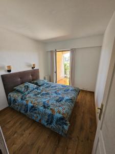 a bedroom with a bed with a blue blanket at Appartement golf de Valescure avec jardin in Saint-Raphaël
