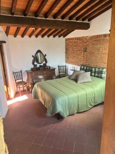 een slaapkamer met een bed, een spiegel en een tafel bij La casa nel borgo in Cavriglia