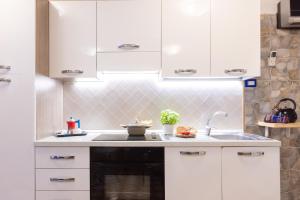 a kitchen with white cabinets and a sink at Marinautica Sea Cottage in Sorrento