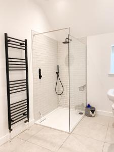 a shower with a glass door in a bathroom at The Annexe - KG Retreats in Ketton