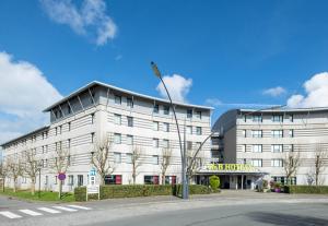 科凱勒的住宿－B&B HOTEL Calais Terminal Cité Europe 3 étoiles，上面有旗帜的白色建筑