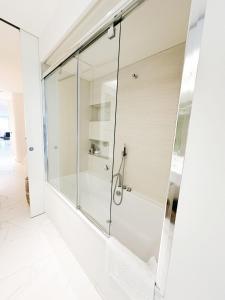 a glass shower in a bathroom with white tiles at LHV Luxury Apartment Boas in Ibiza Town