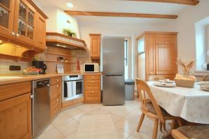 eine Küche mit einem Tisch und einem Kühlschrank aus Edelstahl in der Unterkunft GUN04-FW Apartment in Windsbach in Windsbach