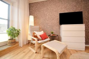 ein Wohnzimmer mit einem Stuhl und einem TV in der Unterkunft GUN04-FW Apartment in Windsbach in Windsbach