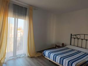 1 dormitorio con cama y ventana grande en Eulogio, en Sant Feliu de Guíxols