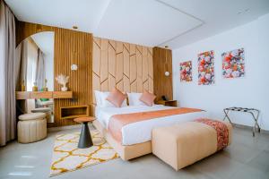 a bedroom with a king sized bed and a stool at TIMAZIN HOTEL DAKHLA in Dakhla