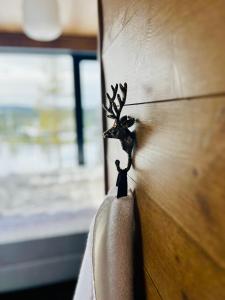 eine Holztür mit einer Hirschfigur drauf in der Unterkunft The Riverside Mountain Lodge - 110sqm of Calm Luxury in Idre