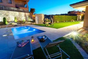 een patio met een tafel en stoelen naast een zwembad bij 5 bedrooms villa with private pool sauna and enclosed garden at Vinaixa in Viñaixa