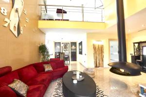 a living room with a red couch and a table at 5 bedrooms villa with private pool sauna and terrace at Vinaixa in Viñaixa