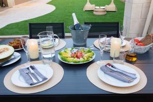 niebieski stół z talerzami jedzenia i kieliszkami do wina w obiekcie 5 bedrooms villa with private pool sauna and terrace at Vinaixa w mieście Viñaixa