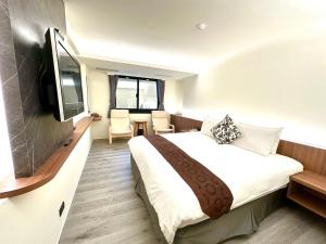 pokój hotelowy z łóżkiem i telewizorem z płaskim ekranem w obiekcie Dafong Hotel w mieście Zhongzheng