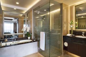 a bathroom with a glass shower and a sink at Anantara Riverside Bangkok Resort in Bangkok