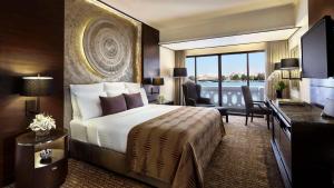 a hotel room with a bed and a large window at Anantara Riverside Bangkok Resort in Bangkok