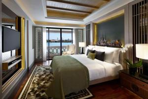 a bedroom with a large bed and a television at Anantara Riverside Bangkok Resort in Bangkok