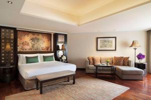 a bedroom with a large bed and a couch at Anantara Riverside Bangkok Resort in Bangkok