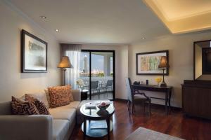 a living room with a couch and a table at Anantara Riverside Bangkok Resort in Bangkok