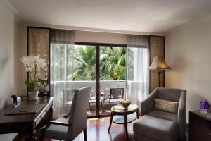 a living room with a desk and a table and chairs at Anantara Riverside Bangkok Resort in Bangkok
