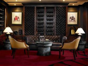 a wine tasting room with a couch and chairs at Anantara Riverside Bangkok Resort in Bangkok