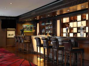 a bar with brown stools in a restaurant at Anantara Riverside Bangkok Resort in Bangkok