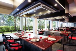 a restaurant with a large bar with chairs and tables at Anantara Riverside Bangkok Resort in Bangkok