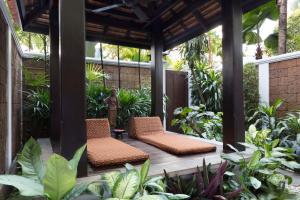 two chairs sitting on a porch with plants at Anantara Riverside Bangkok Resort in Bangkok