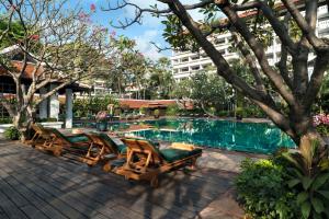 a pool with chaise lounge chairs and a swimming pool at Anantara Riverside Bangkok Resort in Bangkok