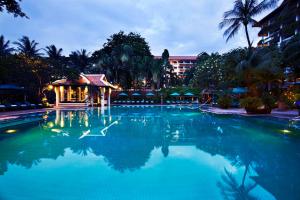 a swimming pool at a resort at night at Anantara Riverside Bangkok Resort in Bangkok