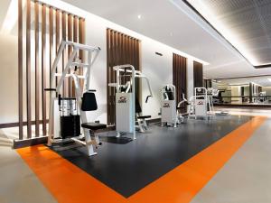 a gym with several treadmills and machines in a room at Anantara Riverside Bangkok Resort in Bangkok