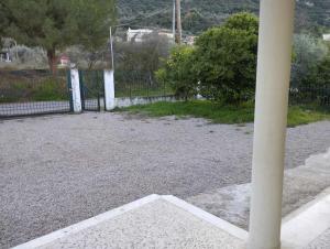 a pole in a gravel parking lot with a fence at Alexas country house in Kamena Vourla