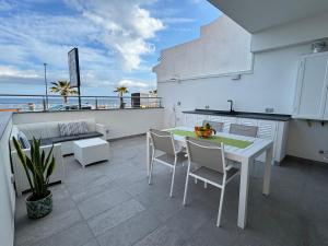 un balcon avec une table et des chaises. dans l'établissement Thetis Apartments, à Furci Siculo