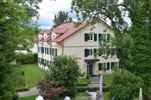 uma grande casa branca com um telhado vermelho em Hotel Mühle em Binzen