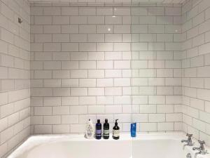 a white bathroom with a tub with bottles on it at Tower Bridge Borough Market London Bridge House in London