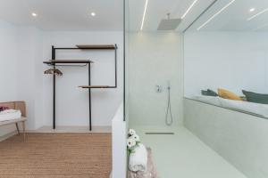 a bathroom with white walls and a glass shower stall at Gold Suite Canteras by Canarias Homelidays in Las Palmas de Gran Canaria +78 photos