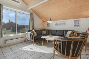 un salon avec un canapé et une table dans l'établissement Cozy holiday house with pool by the sea - SJ940, à Harboør