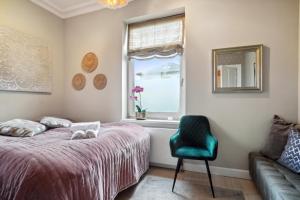ein Schlafzimmer mit einem Bett, einem Stuhl und einem Fenster in der Unterkunft Luksuriøst 3BR Strandhus m.plads til 6 personer in Hellerup