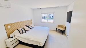 a bedroom with a bed and a chair in it at Your dream Getaway Awaits in Vale do Lobo in Almancil
