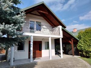 una casa con un balcone e un albero di Domek Chmiel II nad Jeziorem Tarnobrzeskim a Chmielów