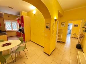 a kitchen with a table and a yellow wall at Il Giardino a Monte Sacro in Rome