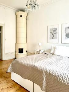 a white bedroom with a bed and a fireplace at Lägenhet med fantastiskt läge in Stockholm
