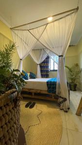 1 dormitorio con 1 cama con dosel en Kitiko residence Hotel, en Entebbe