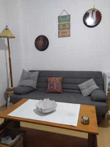 een woonkamer met een blauwe bank en een tafel bij Apartamento en el corazon de Triana in Sevilla