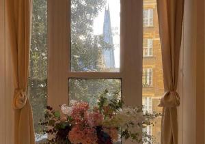 uma janela com um vaso de flores em frente em Tower Bridge Borough Market London Bridge House em Londres