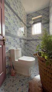 ein Bad mit einem weißen WC und einem Fenster in der Unterkunft Kitiko residence Hotel in Entebbe
