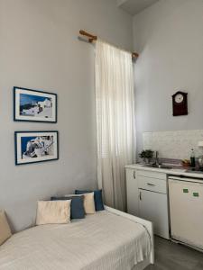 a bedroom with two beds and a kitchen with a sink at BYZANTIUM APARTMENTS in Ermoupoli
