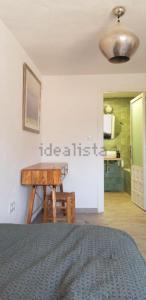 a bedroom with a bed and a table with a chair at Barrio Andaluz apartment in Almuñécar