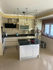 a kitchen with white cabinets and a black counter top at Welcoming house with terrace and garden in Barra de Mira in Areão