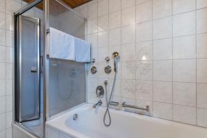 a bathroom with a shower and a tub at Fewo Schwarzwald - Haus Sommerberg in Baiersbronn +14 photos