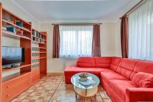 a living room with a red couch and a tv at Apart Dirndltal in Loich